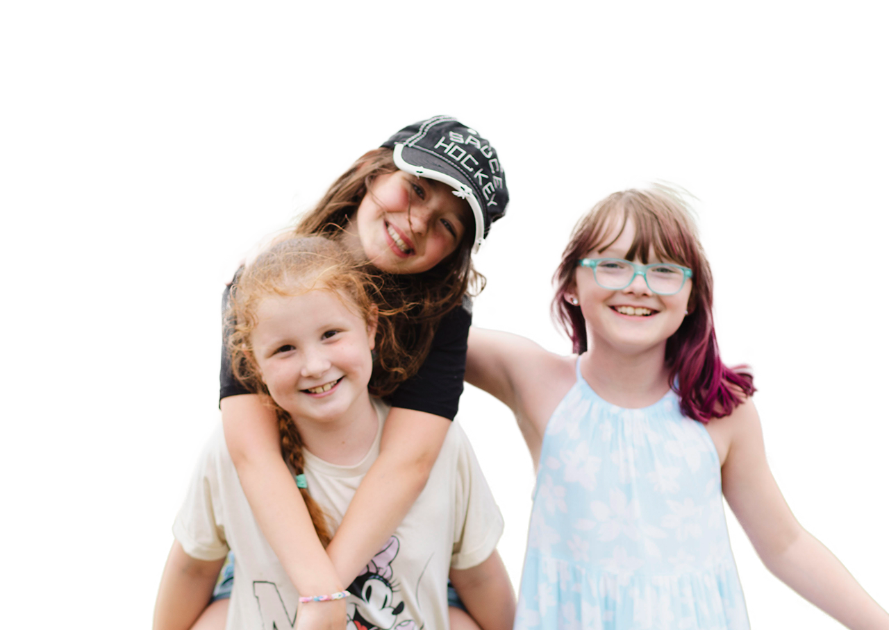 Three young girls smiling at the camera.