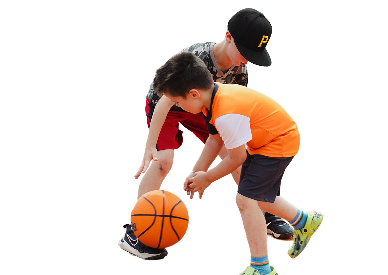 Two young boys playing basketball.