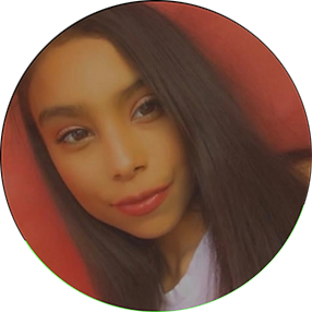 A young woman with long, straight dark hair, wearing a white top.
